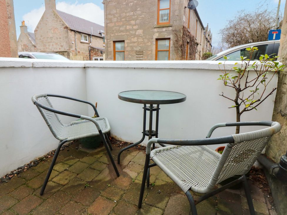 An outdoor seating area with a table and chairs at Rose Cottage Nairn