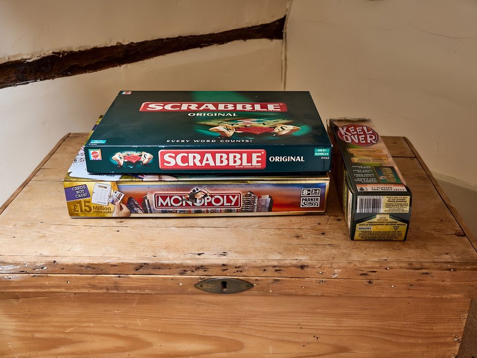 A wooden box with board games Scrabble and Monopoly at Evas Cottage Southam
