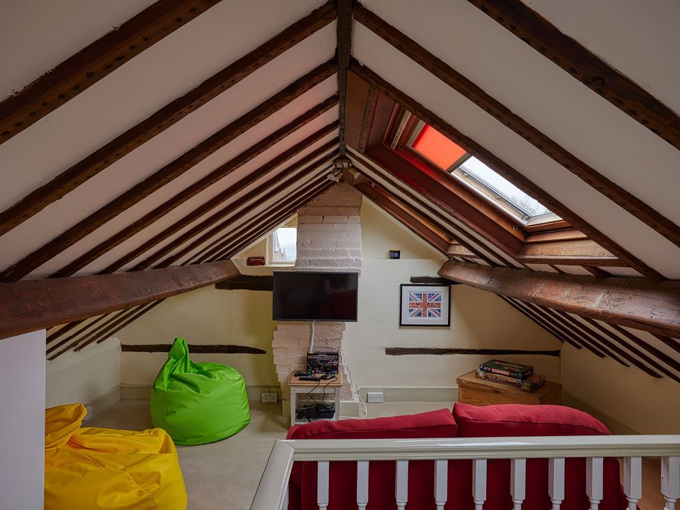 An attic space with bean bags and a television at Evas Cottage in Southam