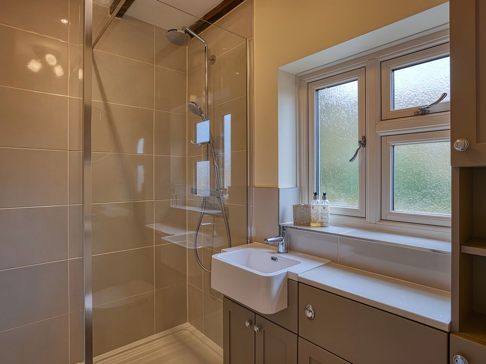 A bathroom with a shower and sink at Evas Cottage in Southam