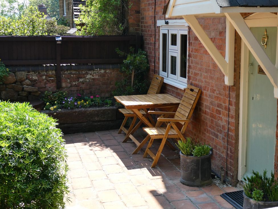 A garden area with a table and chairs at Evas Cottage Southam