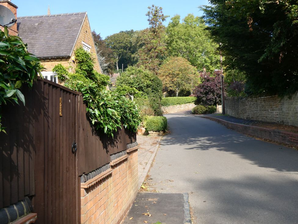 A street view with a house and greenery at Evas Cottage in Southam