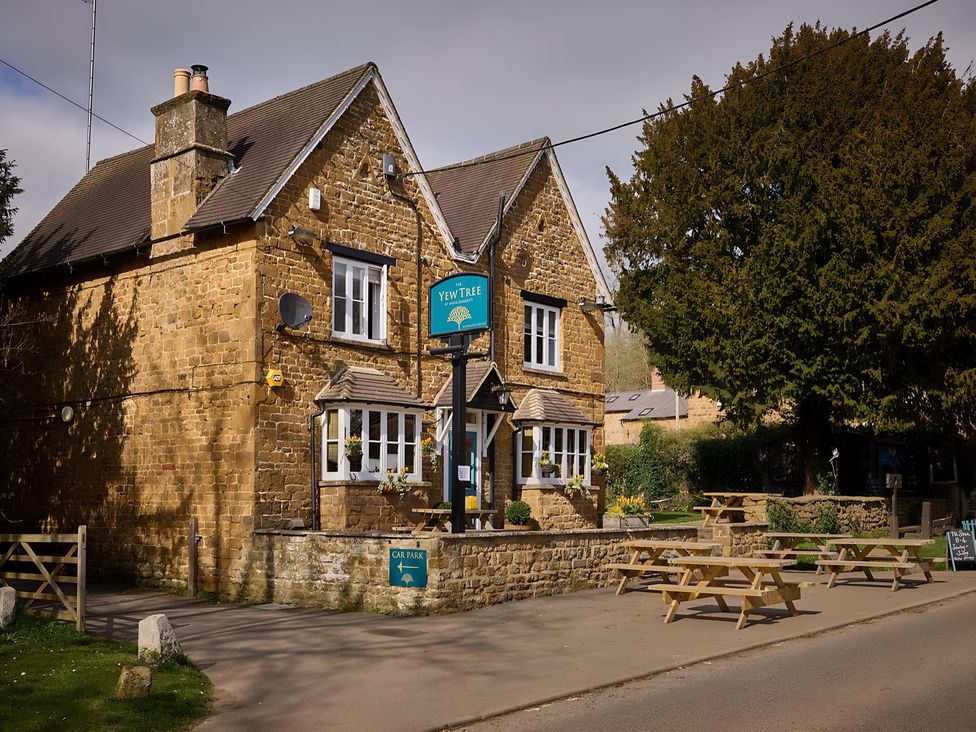 A pub building named Yew Tree with outdoor seating in Southam