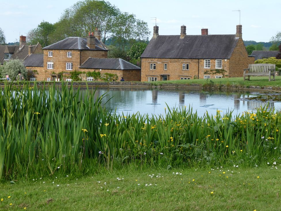 A view of houses next to a pond at Evas Cottage in Southam
