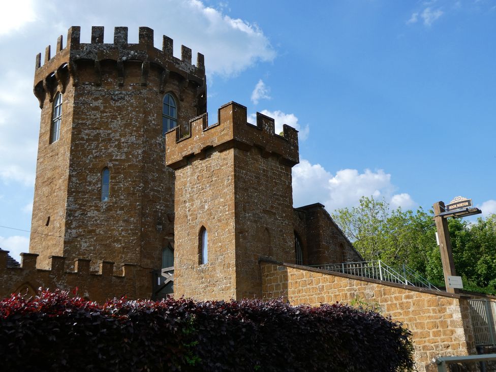 A castle structure with towers and a signpost at Evas Cottage in Southam