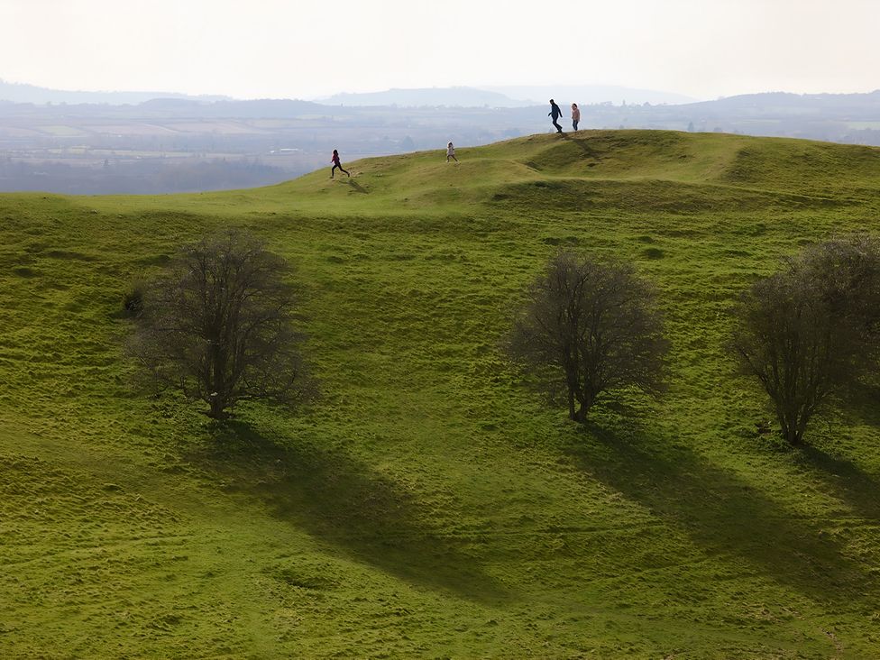 People walking on hills with trees at Evas Cottage in Southam