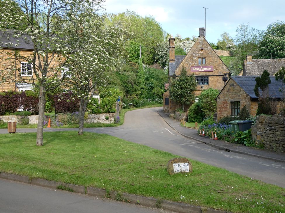 A street view with trees and a pub at Evas Cottage in Southam