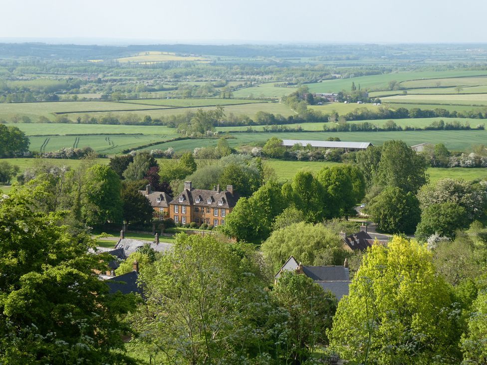 A view of houses and greenery from a hill at Evas Cottage Southam