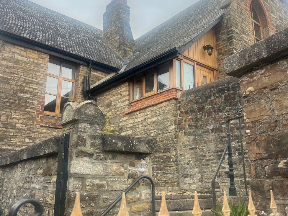 An outdoor view of a house with stone walls and windows at 4 Bickington Road Barnstaple