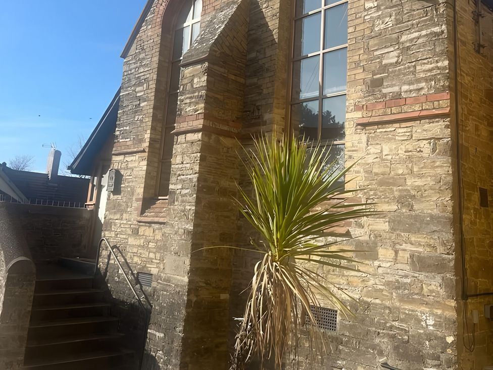 A building with a stone wall and a plant in the outdoor area at 4 Bickington Road Barnstaple