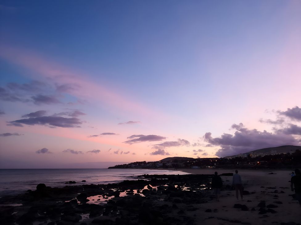 A beach scene with people walking near the water at 4 Bickington Road in Barnstaple