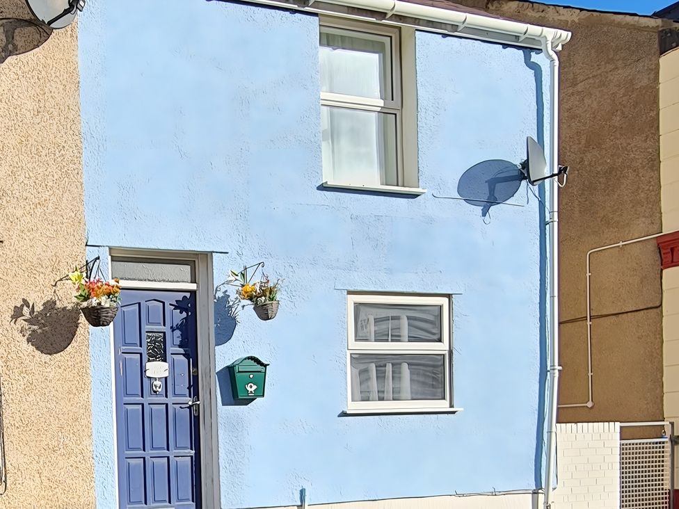 An exterior view of a house with a blue door and window at Blue Haven in Penmaenmawr