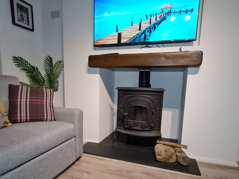 A living room with a sofa and fireplace at Blue Haven in Penmaenmawr