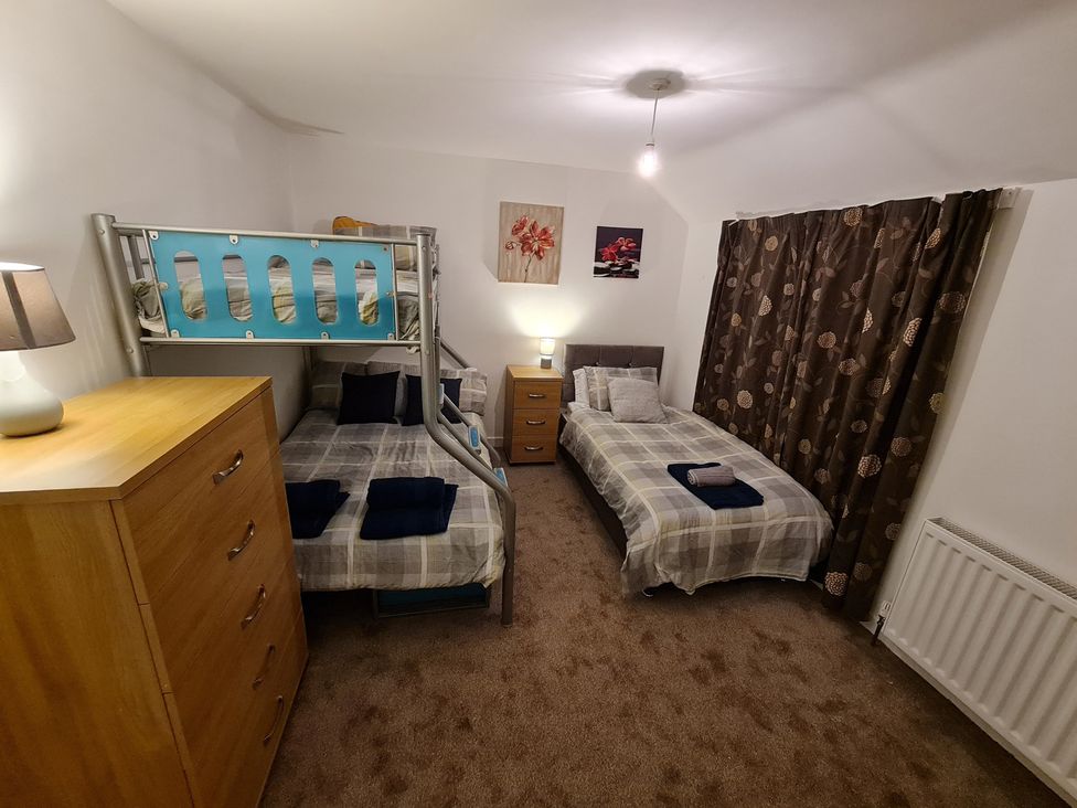 A bedroom with bunk bed and two single beds at Blue Haven in Penmaenmawr