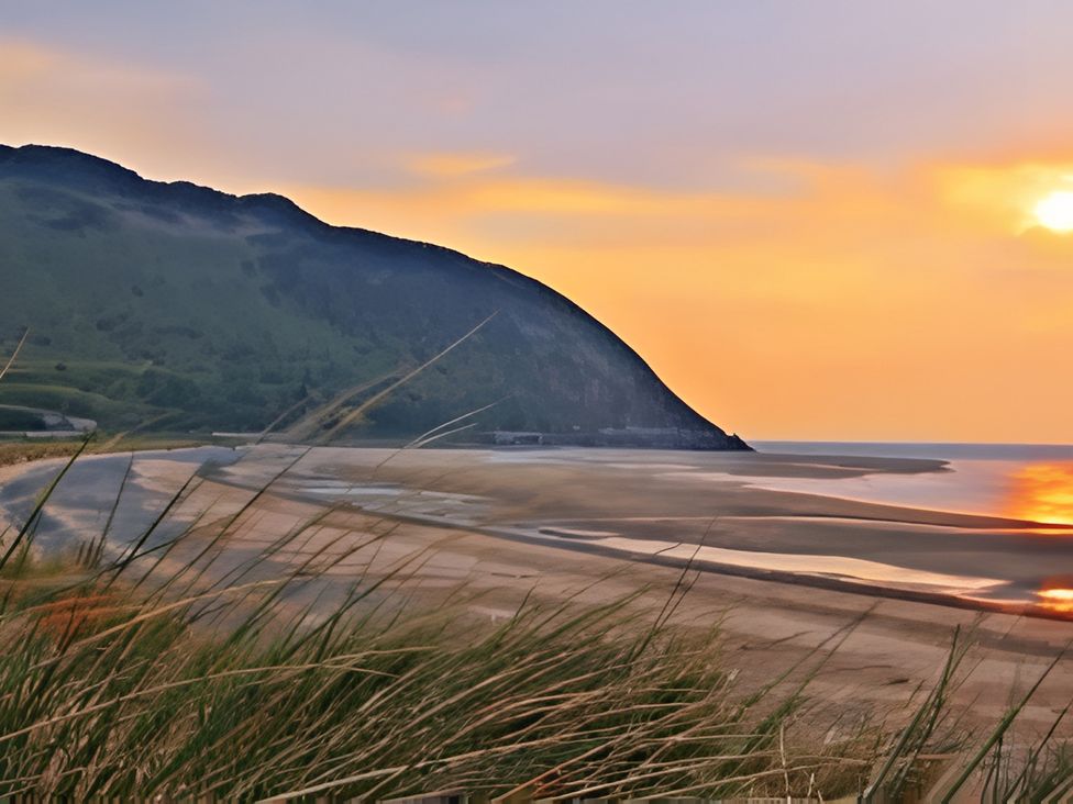 A beach with hills and sunset at Blue Haven in Penmaenmawr