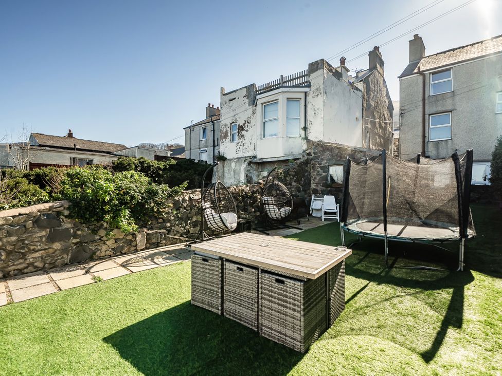 A garden with a trampoline and hanging chairs at Blue Haven in Penmaenmawr