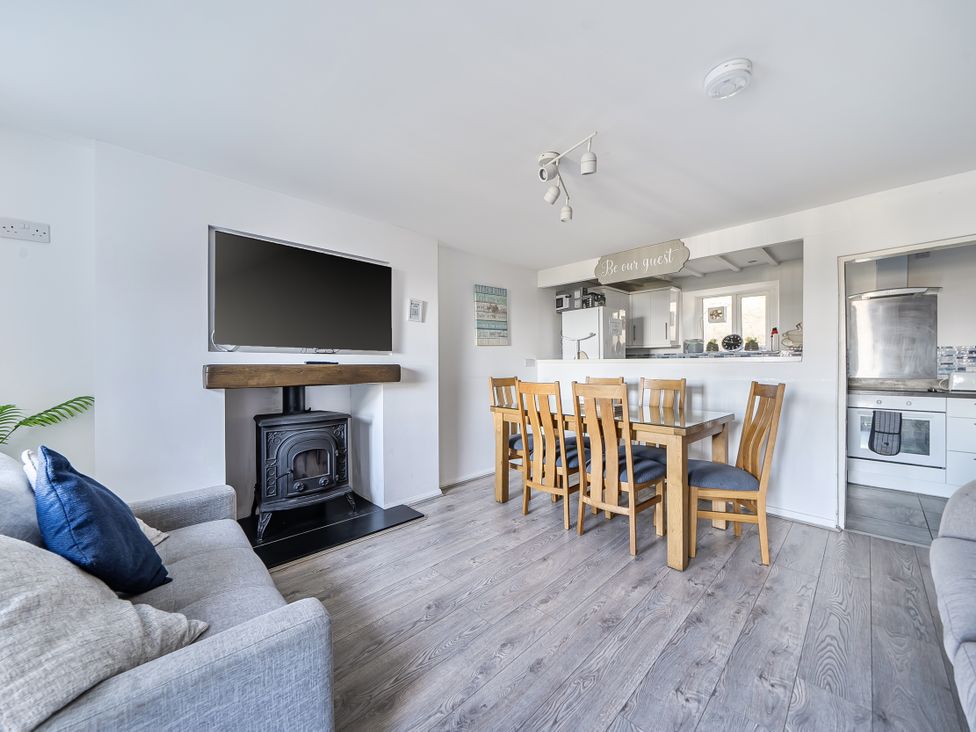 A living room with a television and dining area at Blue Haven in Penmaenmawr