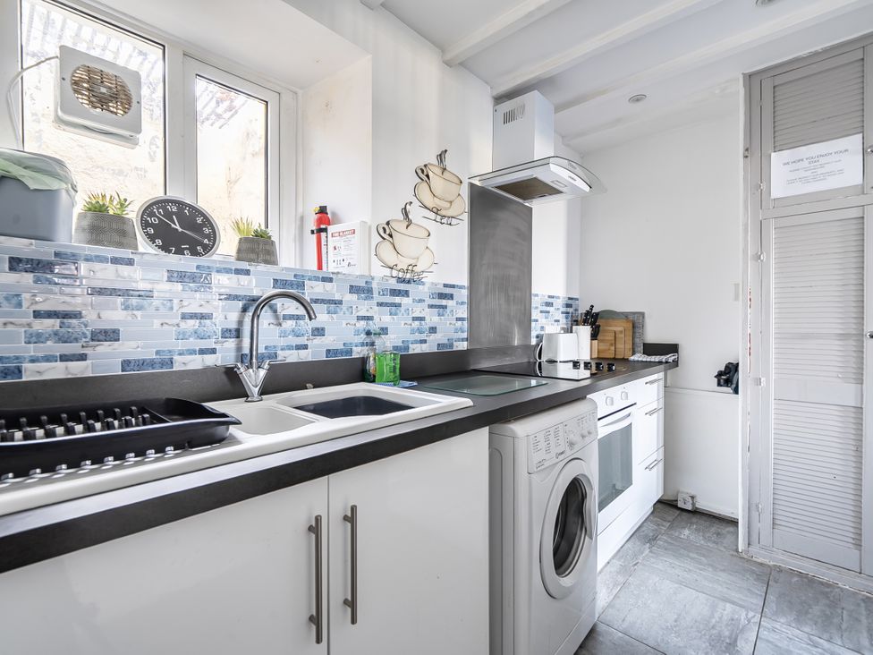 A kitchen with a sink and washing machine at Blue Haven in Penmaenmawr