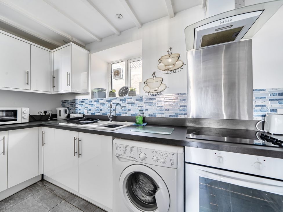 A kitchen with cabinets, sink, and appliances at Blue Haven in Penmaenmawr