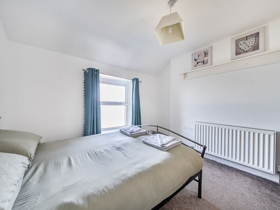 A bedroom with a bed and window at Blue Haven in Penmaenmawr