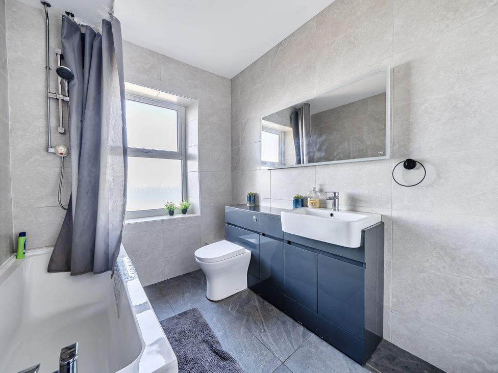 A bathroom with a bathtub, toilet, and sink at Blue Haven in Penmaenmawr