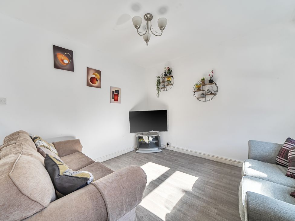 A living room with a sofa and a television at Blue Haven in Penmaenmawr