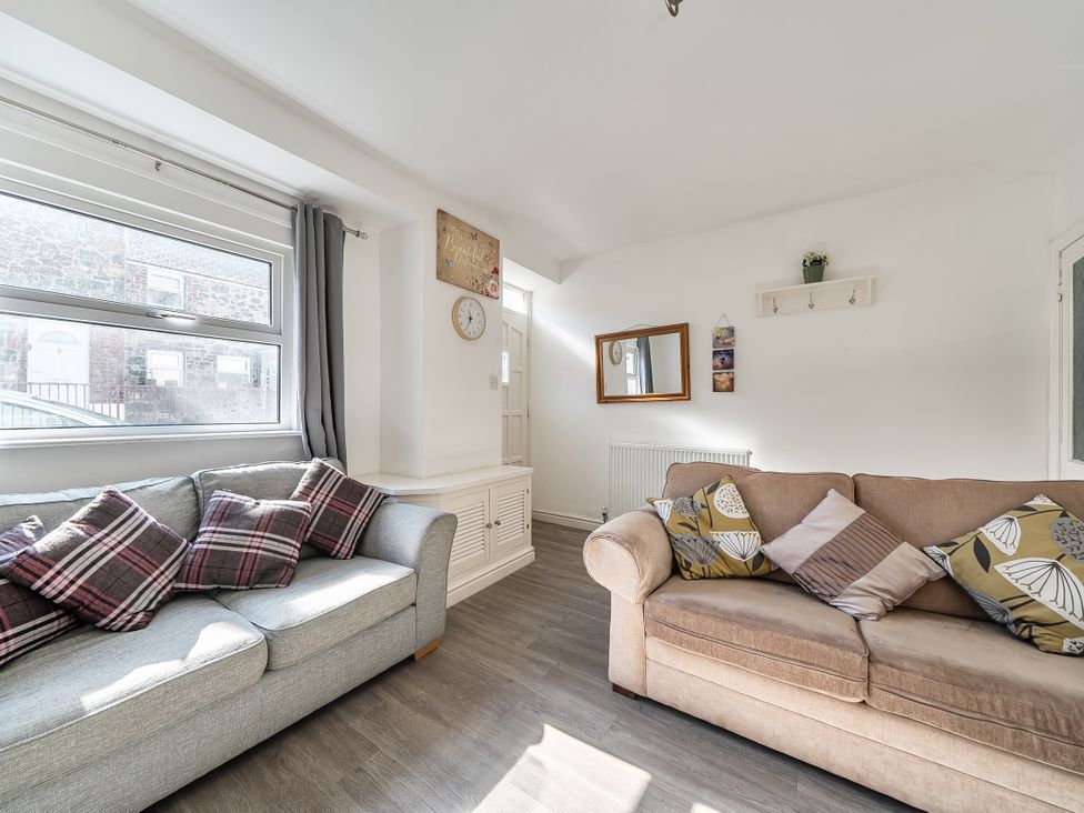 A living room with sofas and a window at Blue Haven in Penmaenmawr