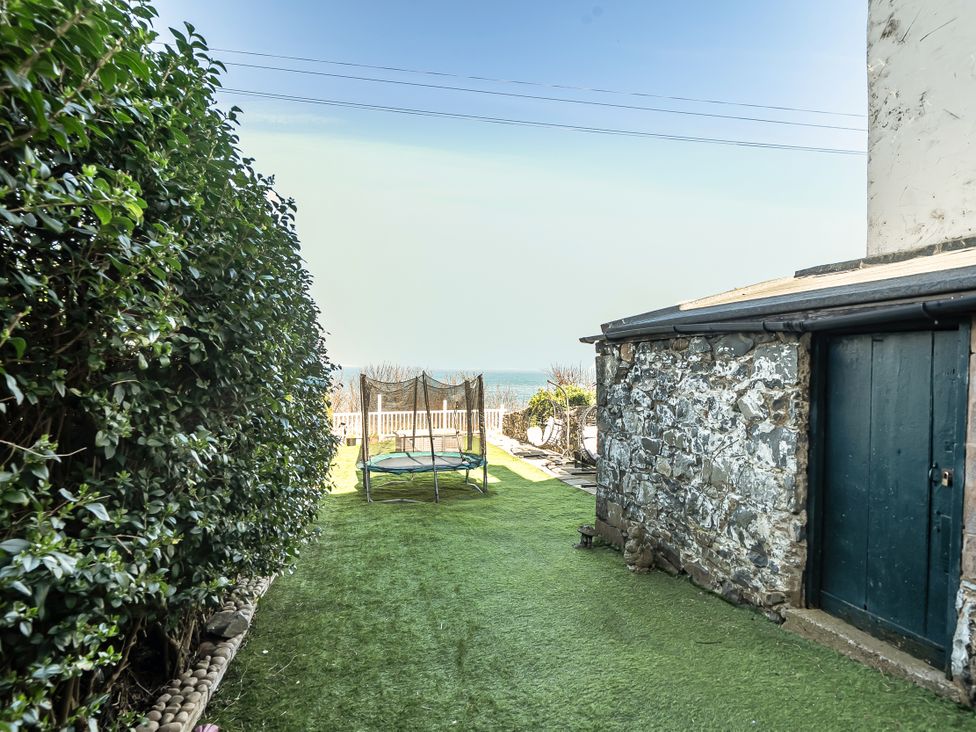 A garden with a trampoline and hedge at Blue Haven in Penmaenmawr