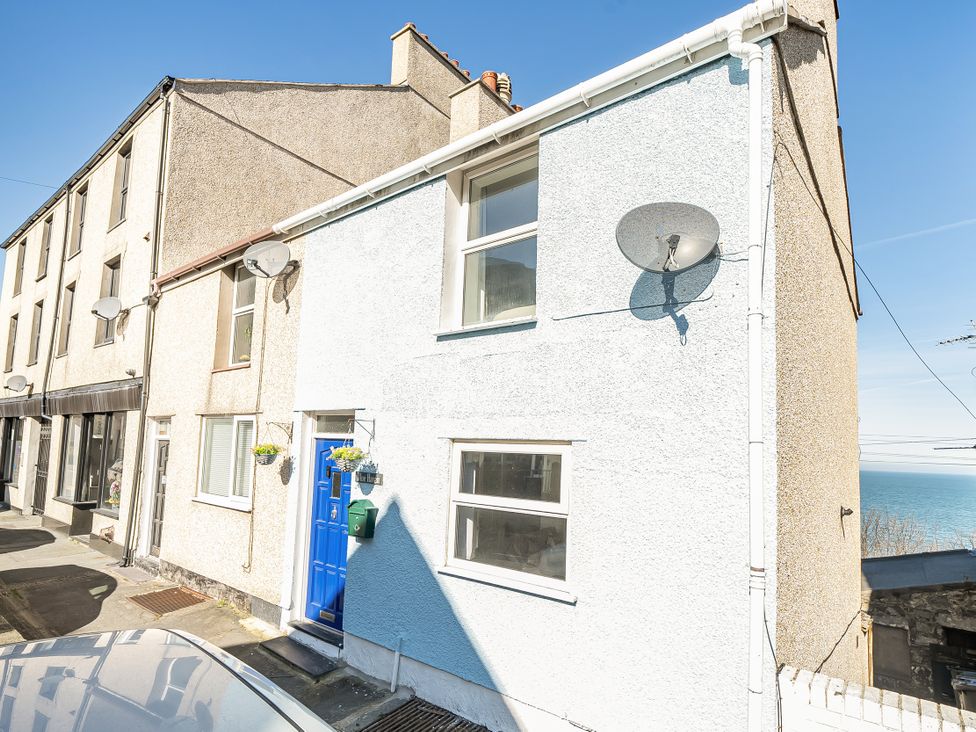 A house with a blue door and satellite dish at Blue Haven in Penmaenmawr