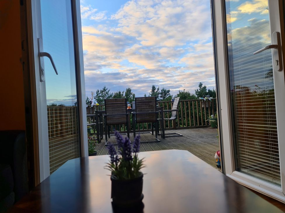 A table with a flower pot and outdoor furniture at Sea View Escape Penmaenmawr