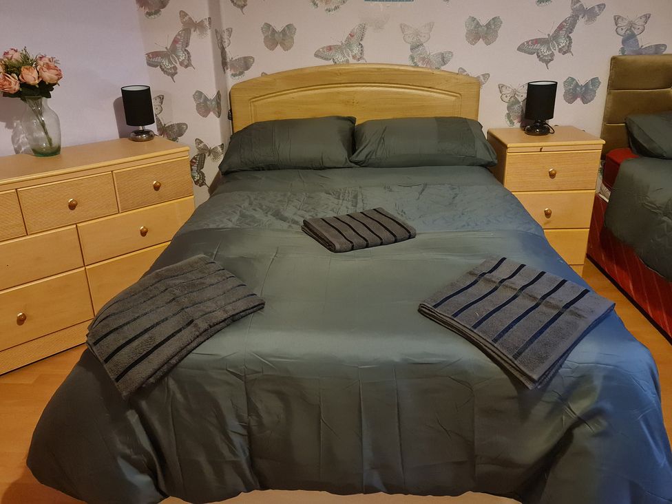 A bedroom with a bed and dresser at Sea View Escape in Penmaenmawr