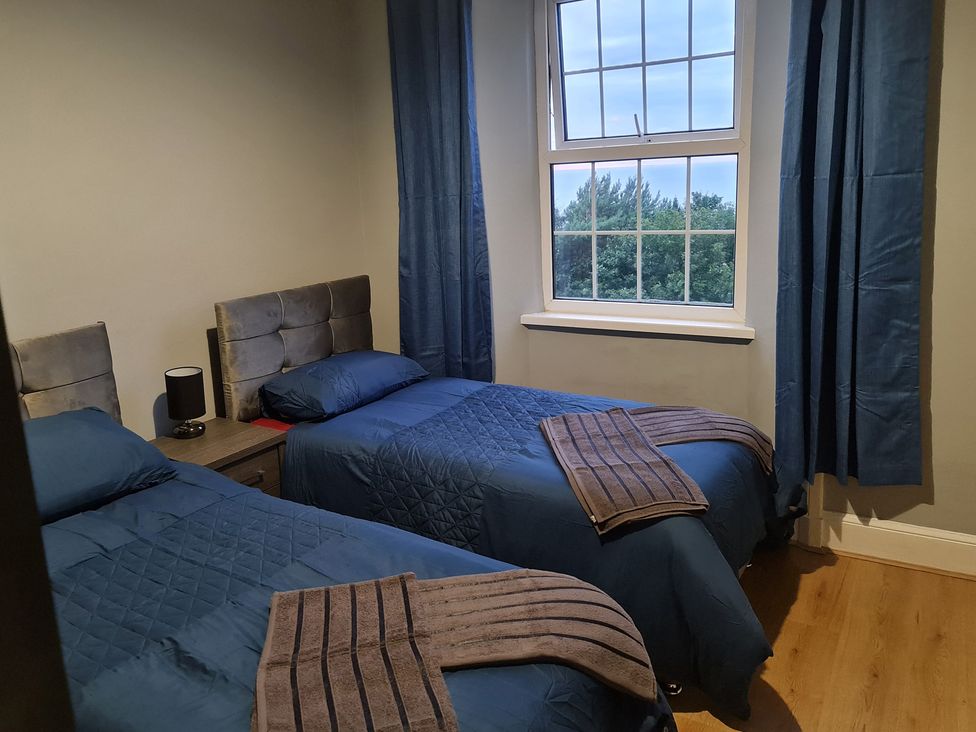 A bedroom with two single beds and a window at Sea View Escape in Penmaenmawr