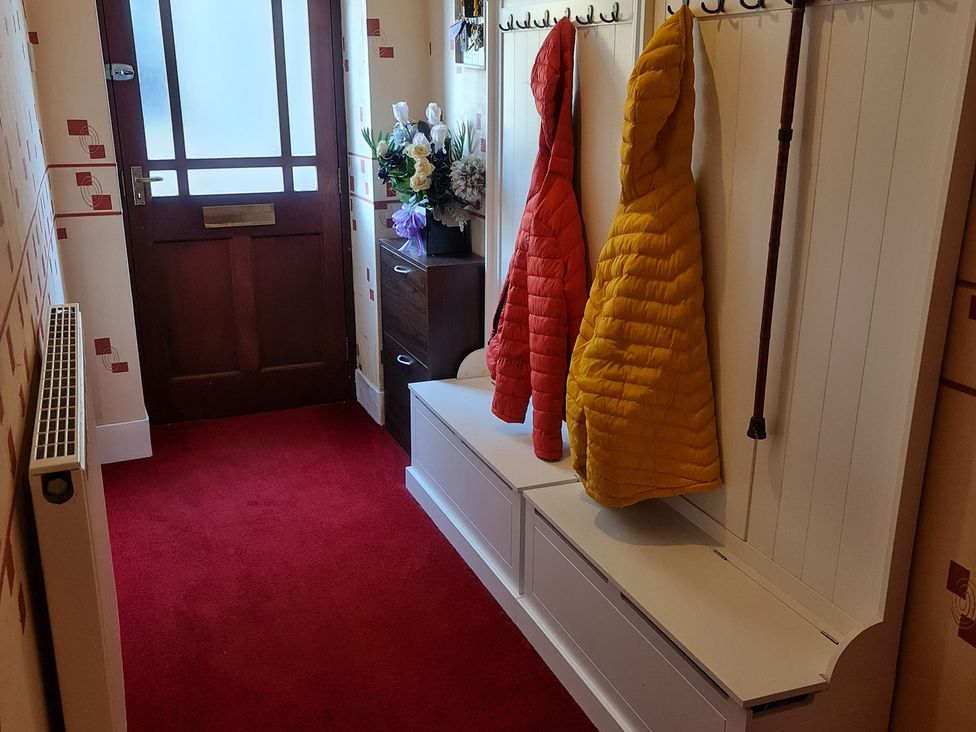 A hallway with a front door and coats hanging at Sea View Escape in Penmaenmawr