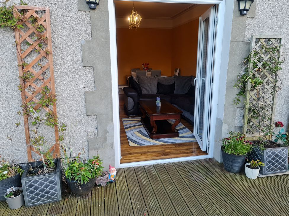 A living room with a table and seating visible from an outdoor area at Sea View Escape in Penmaenmawr
