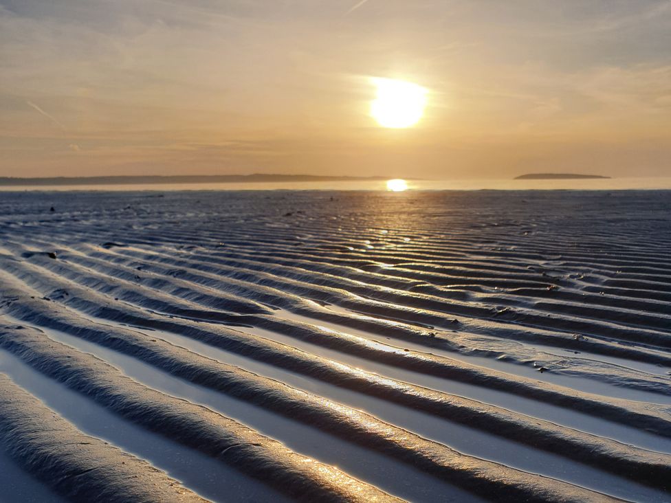 A beach with rippled sand and sunset at Sea View Escape Penmaenmawr