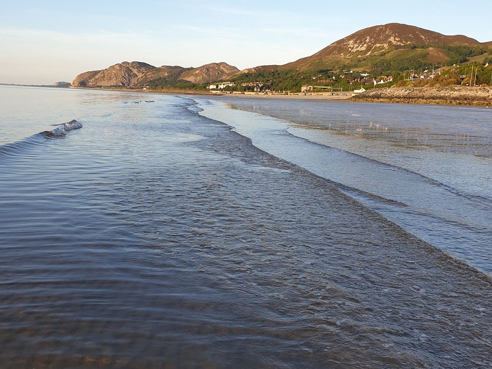 A beach scene with water and hills in the background at Sea View Escape Penmaenmawr