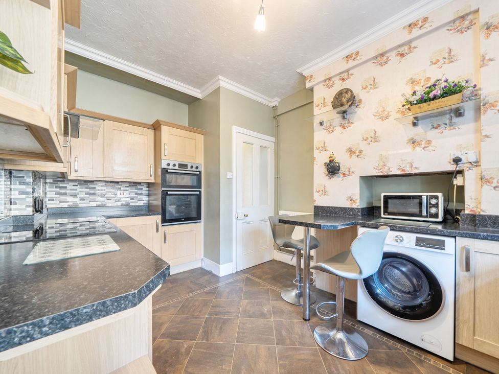 A kitchen with an oven, microwave, and washing machine at Sea View Escape, Penmaenmawr