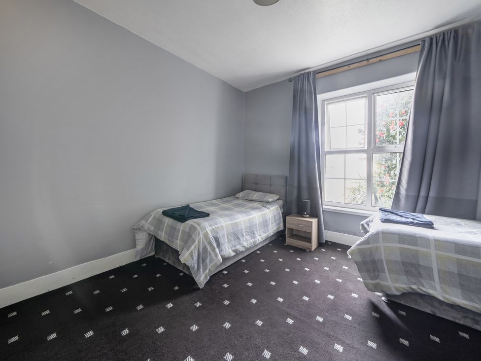 A bedroom with two beds and a window at Sea View Escape Penmaenmawr