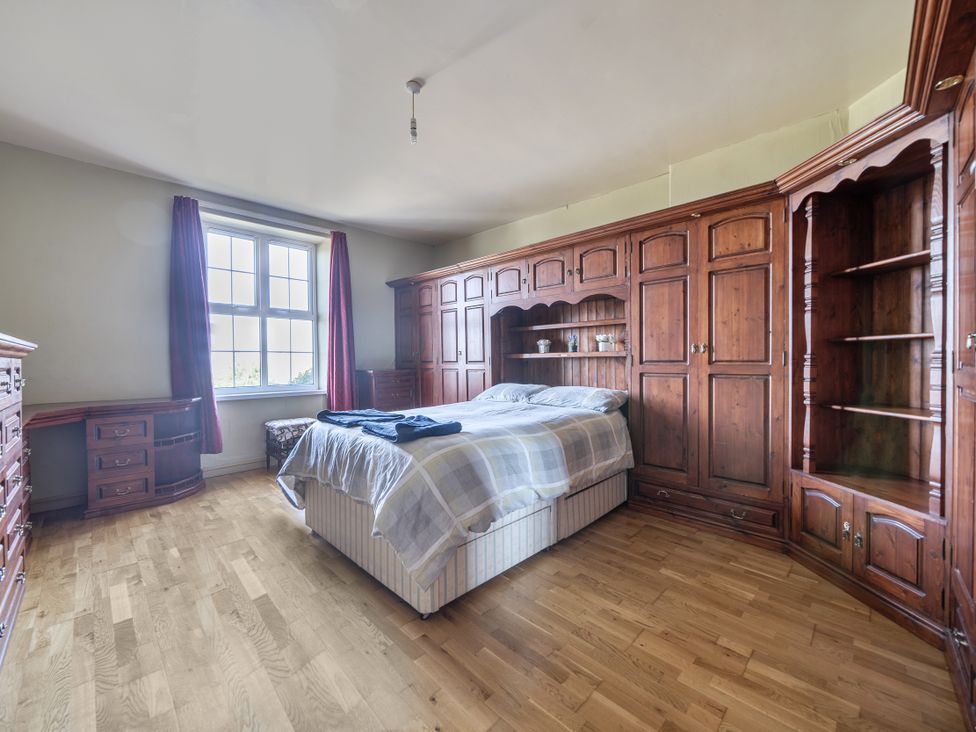 A bedroom with a bed and wooden furniture at Sea View Escape in Penmaenmawr