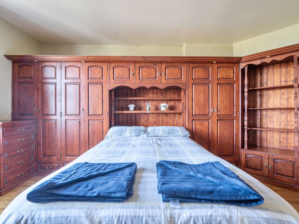 A bedroom with a bed and wooden furniture at Sea View Escape in Penmaenmawr