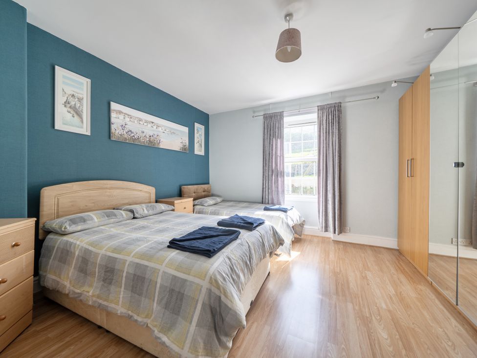 A bedroom with two beds and a wardrobe at Sea View Escape Penmaenmawr