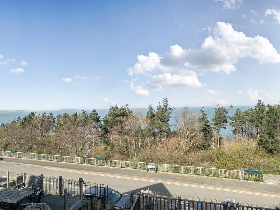A view of the ocean surrounded by trees at Sea View Escape in Penmaenmawr