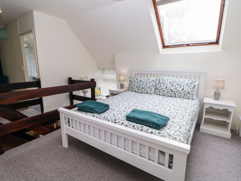 A bedroom with a bed and nightstands at Meadow View Cottage in Matlock