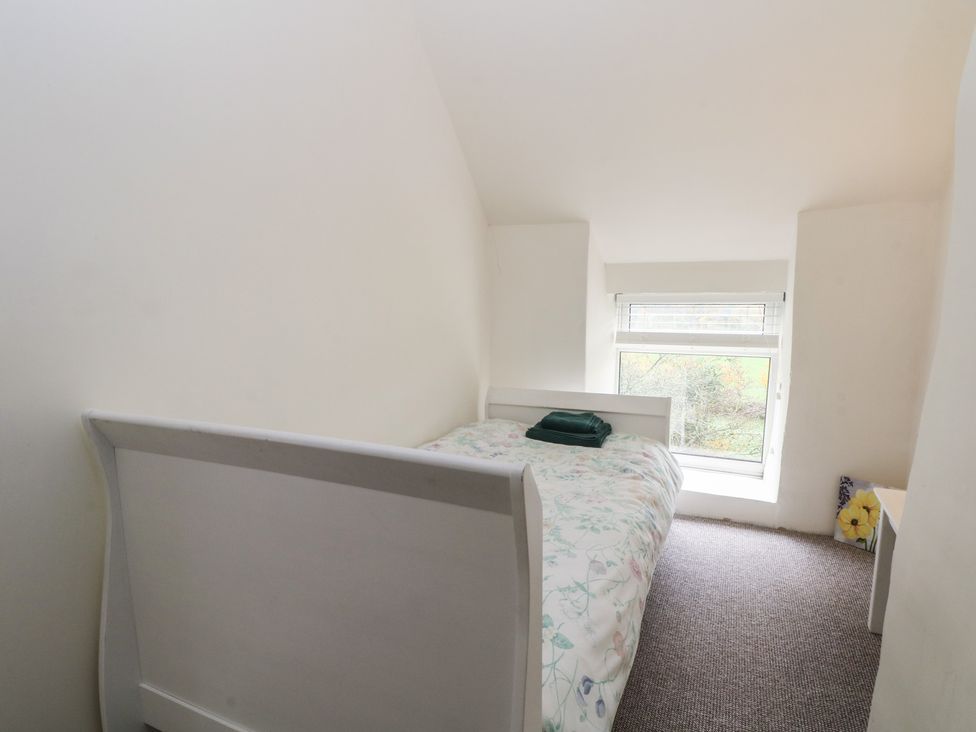 A bedroom with a bed and a window at Meadow View Cottage in Matlock