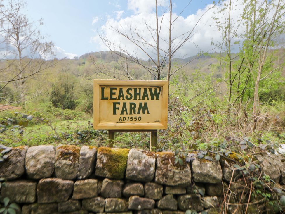A farm sign at Leashaw Farm near a stone wall