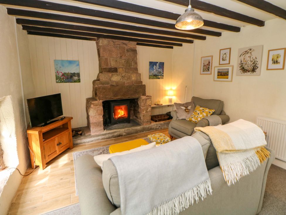 A living room with a fireplace and sofa at Meadow View Cottage Whatstandwell near Crich