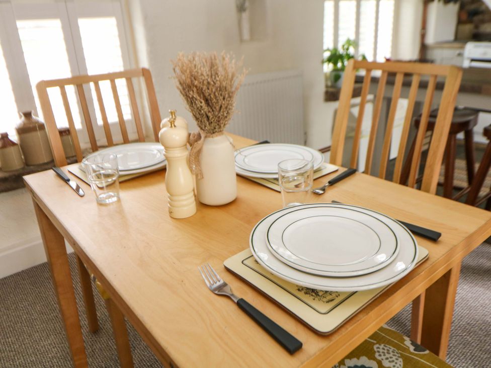 A dining table set with plates and cutlery at Meadow View Cottage Whatstandwell near Crich