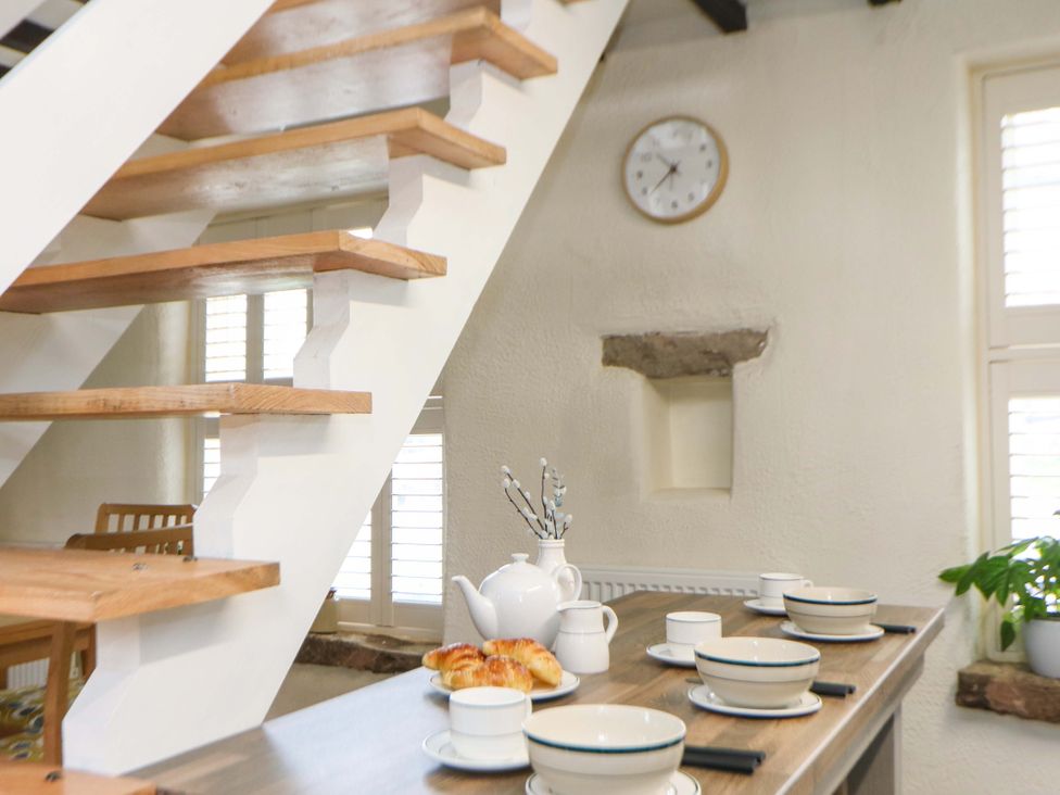 A kitchen with a staircase and table set for breakfast at Meadow View Cottage Whatstandwell near Crich