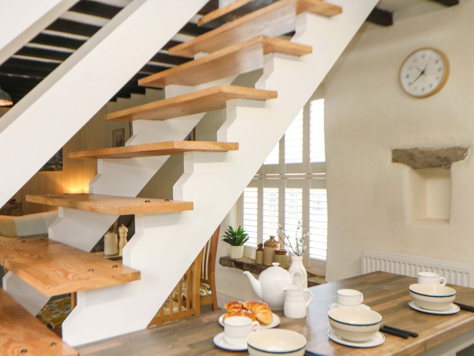 A kitchen with a staircase and a table set for tea at Meadow View Cottage Whatstandwell near Crich