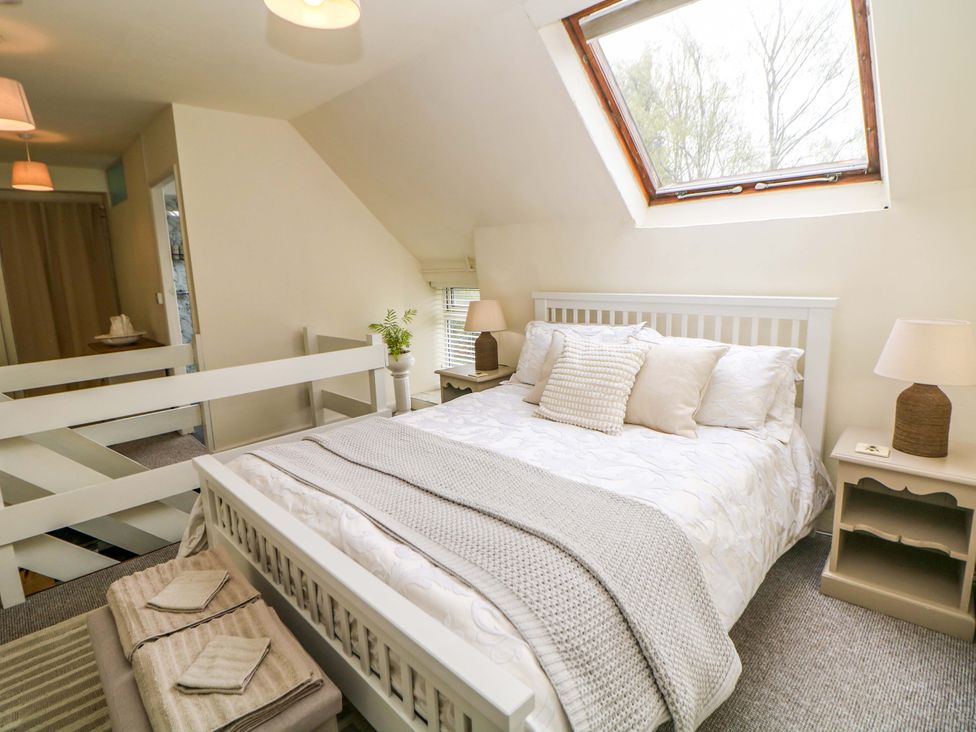 A bedroom with a bed and bedside table at Meadow View Cottage in Whatstandwell near Crich